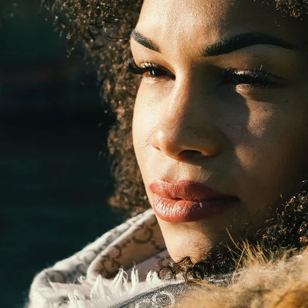 Young women looks in to distance with sun on her skin