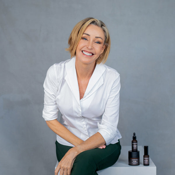 Woman sitting on bench with skincare products sitting beside her